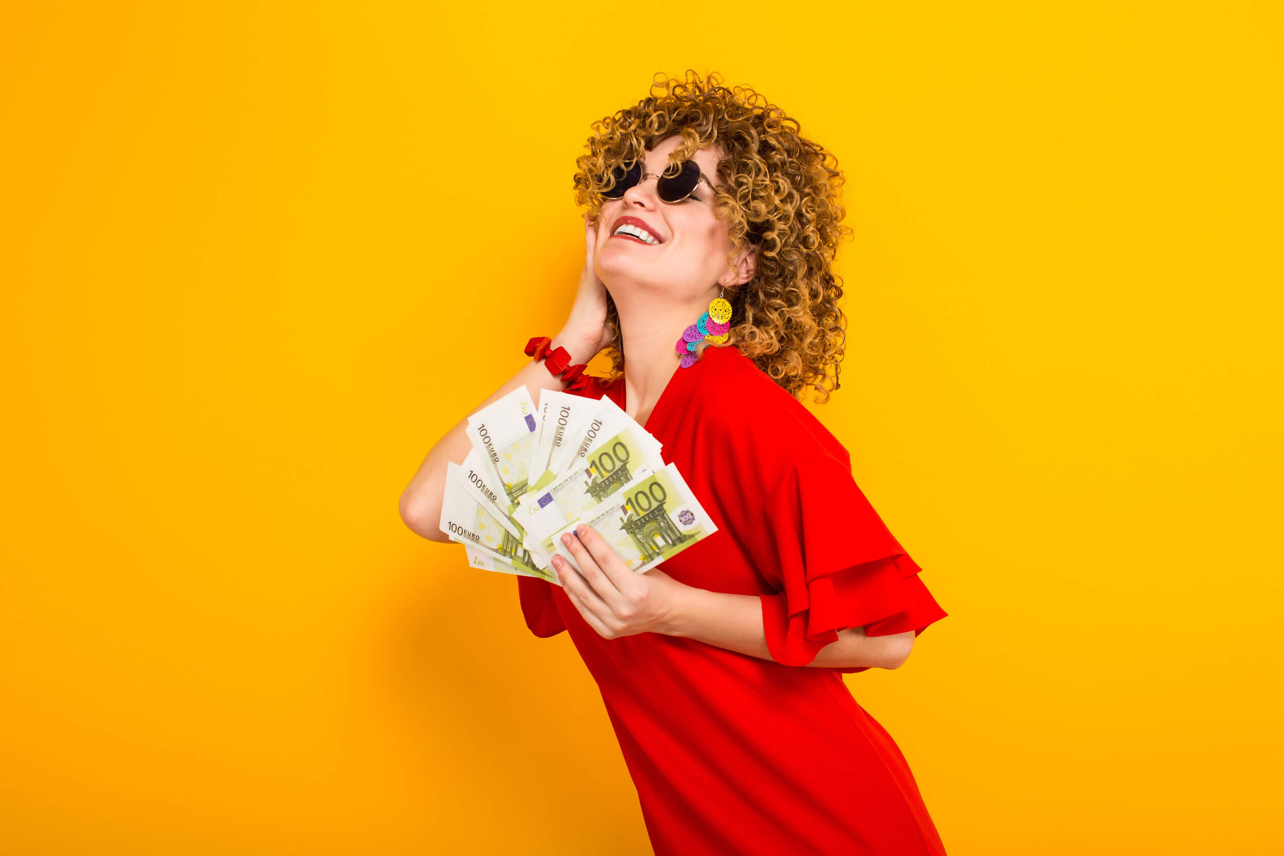 femme tient des billets en éventail