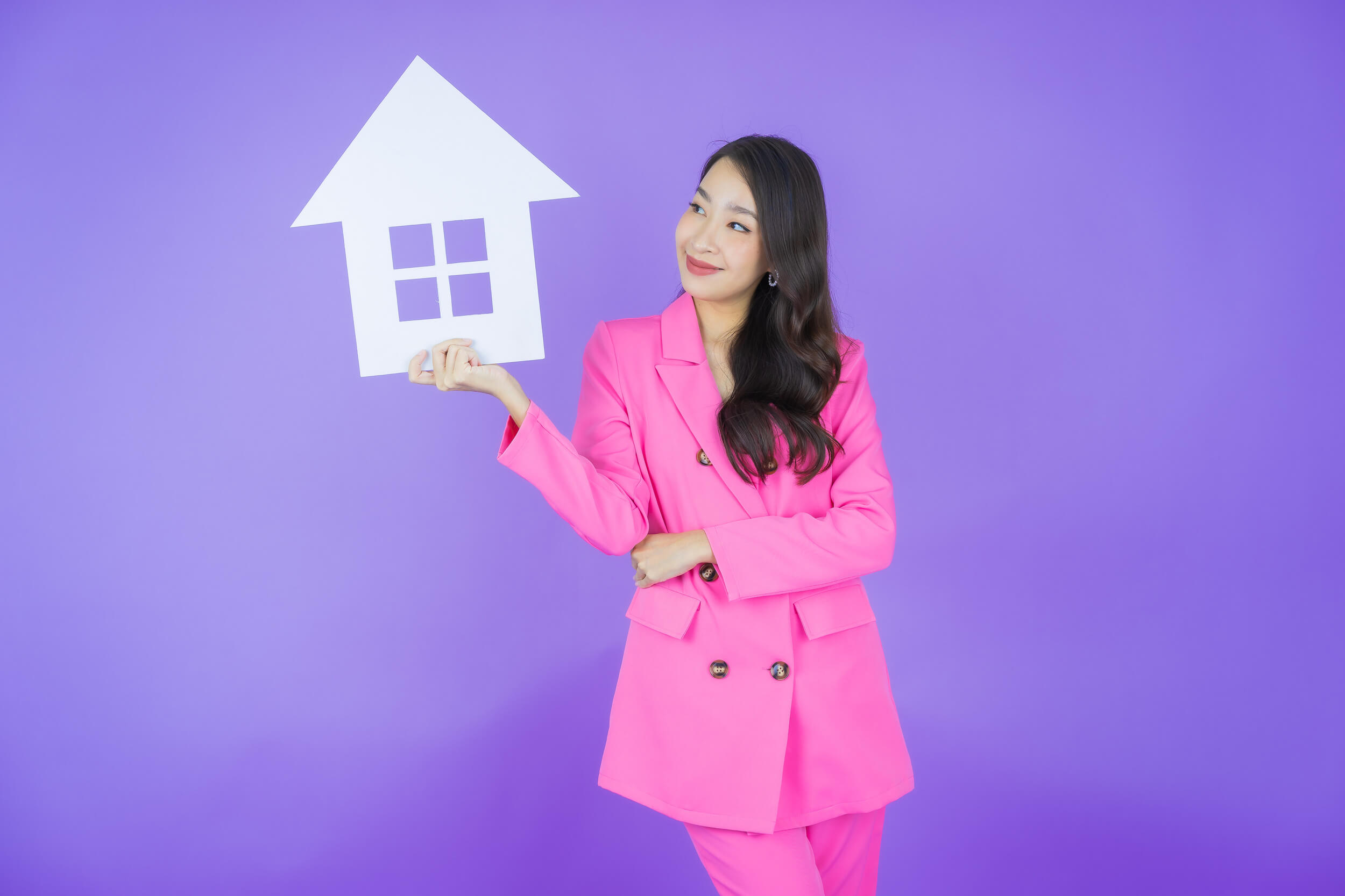 femme tient une maison en carton