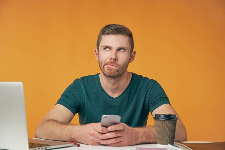 homme perplexe avec son telephone