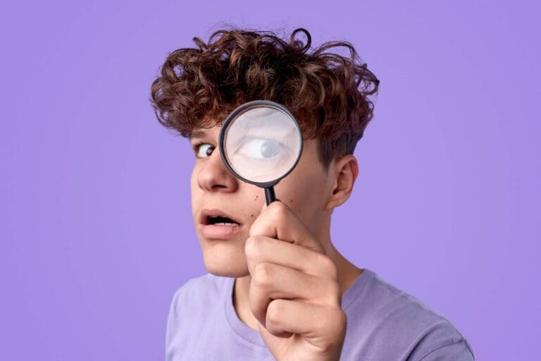 homme avec une loupe devant les yeux