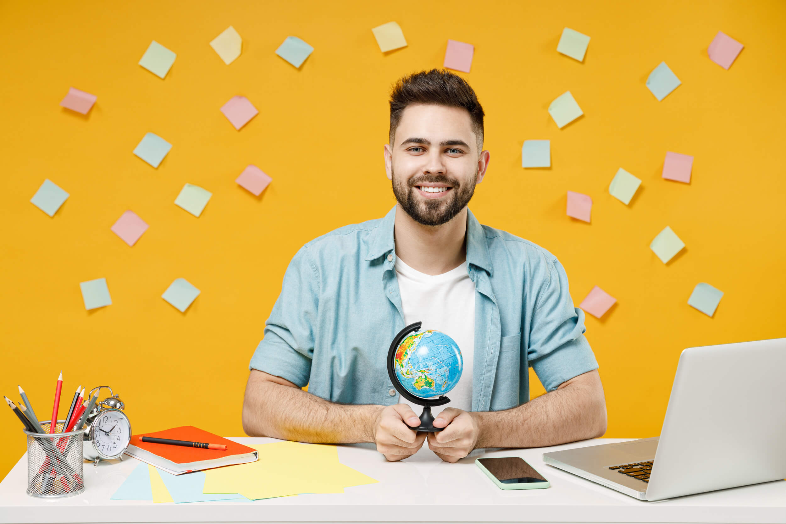 home qui tient une petite map monde