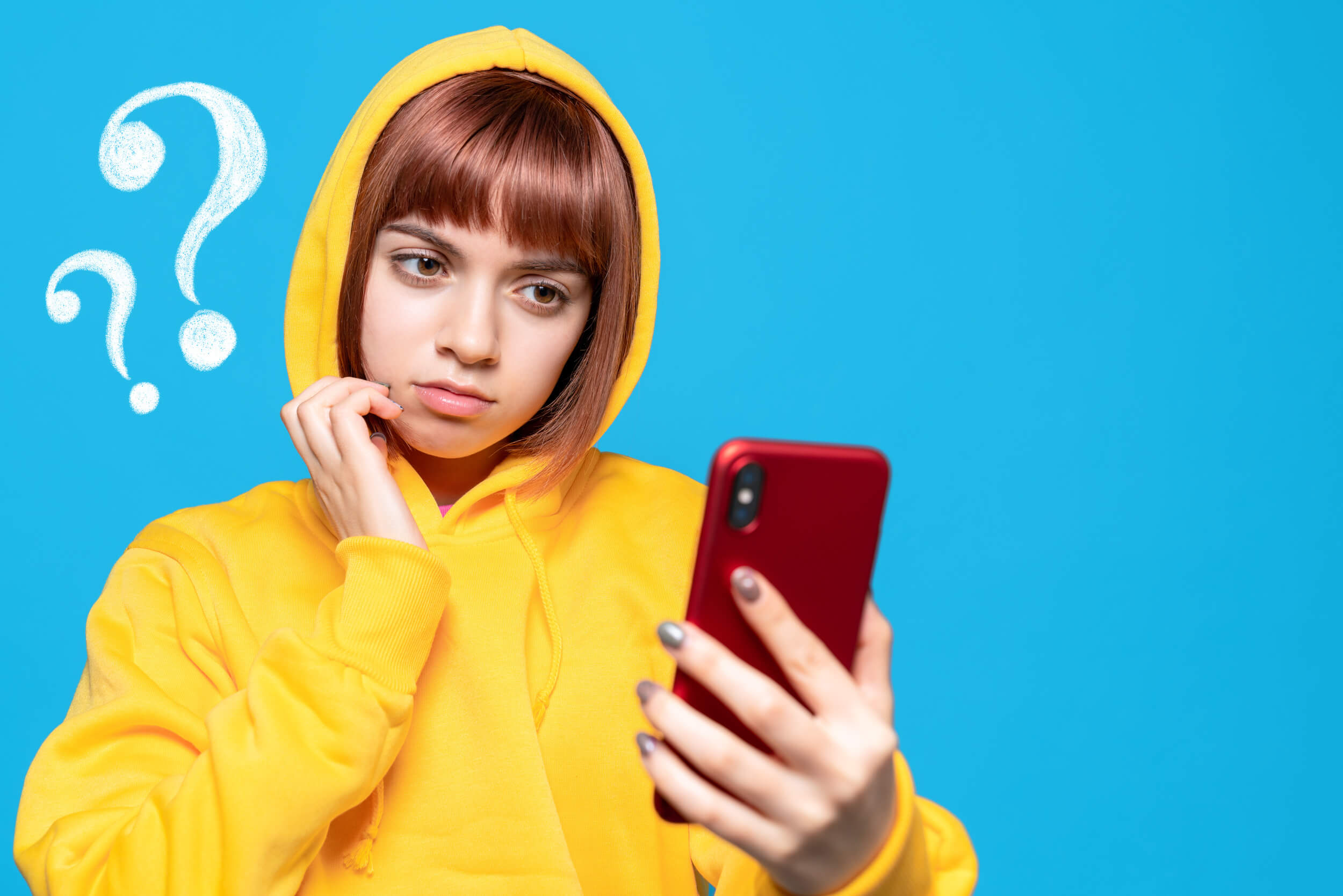 femme se pose des question avec son téléphone