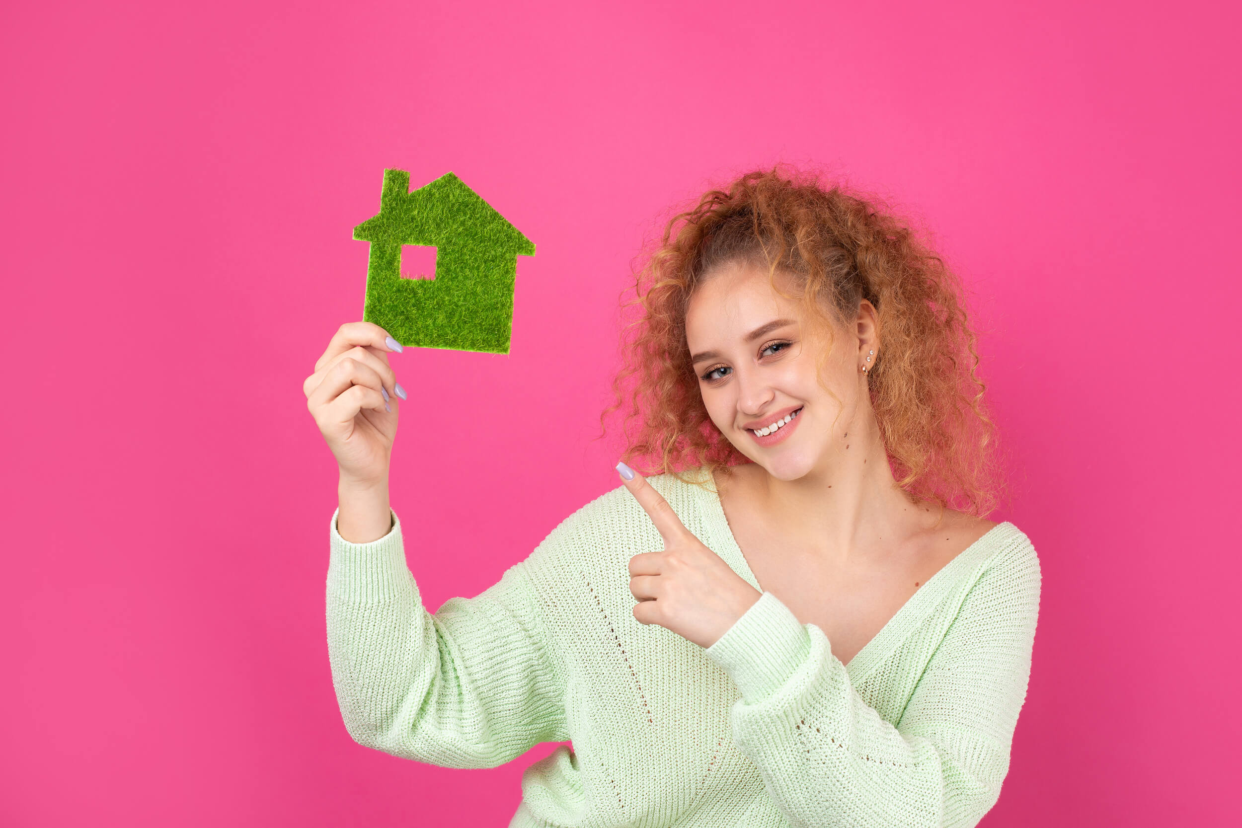 femme tient une petite maison en herbe