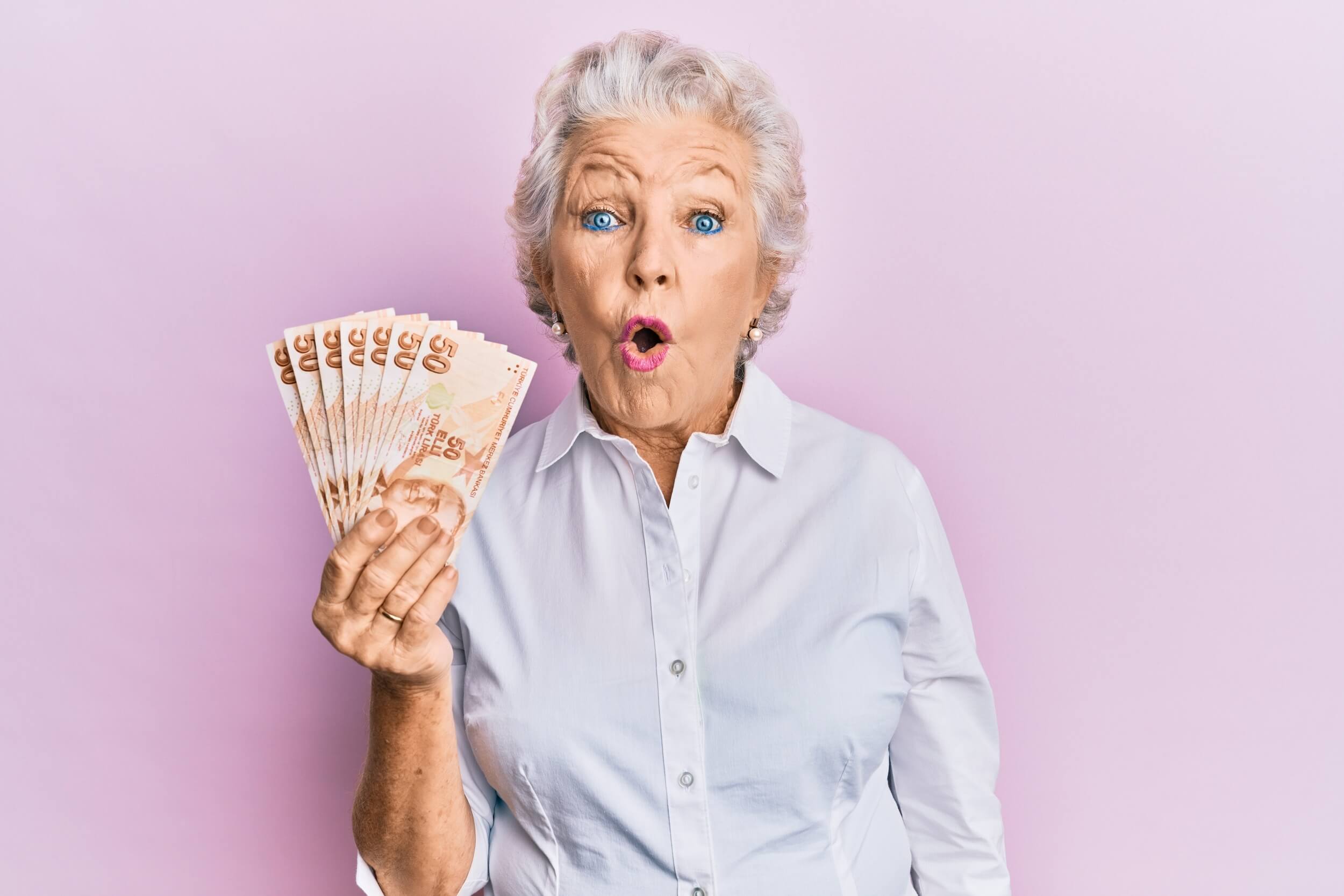 vieille dame tient des billets dans sa main